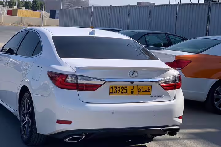 Rear view of a sleek white luxury car with Omani license plate, ideal for exploring Muscat with a private driver.