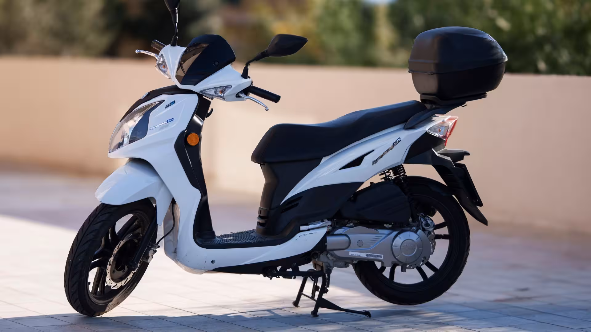 Modern white scooter with sleek design and rear storage box, perfect for convenient and efficient travel around Olbia.