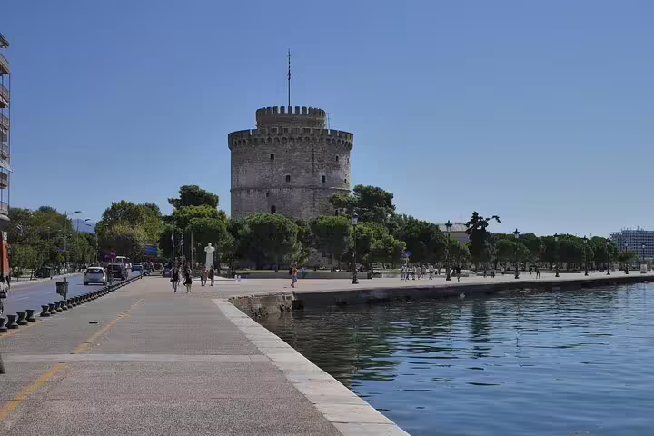 The White Tower beside the serene Thessaloniki waterfront, a must-see on a Greece private tour itinerary.