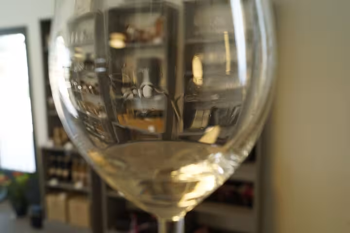 Close-up of white wine in a glass during Pce's Vineyard sommelier course, set in a cozy wine tasting room
