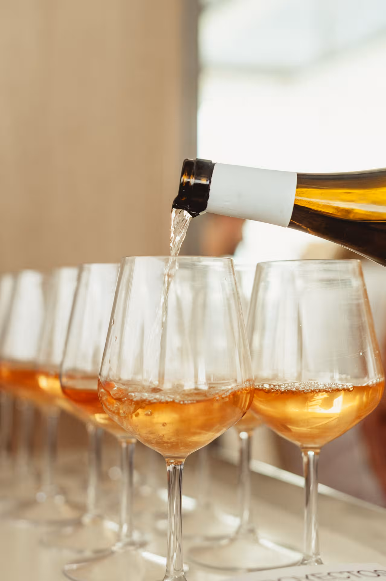 White wine being poured into tasting glasses, perfect for a Wine & Art paint-and-sip experience