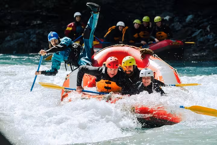 Adventurous rafters in Engadin tackling exciting rapids, showcasing teamwork and joy on a sunny whitewater rafting day.