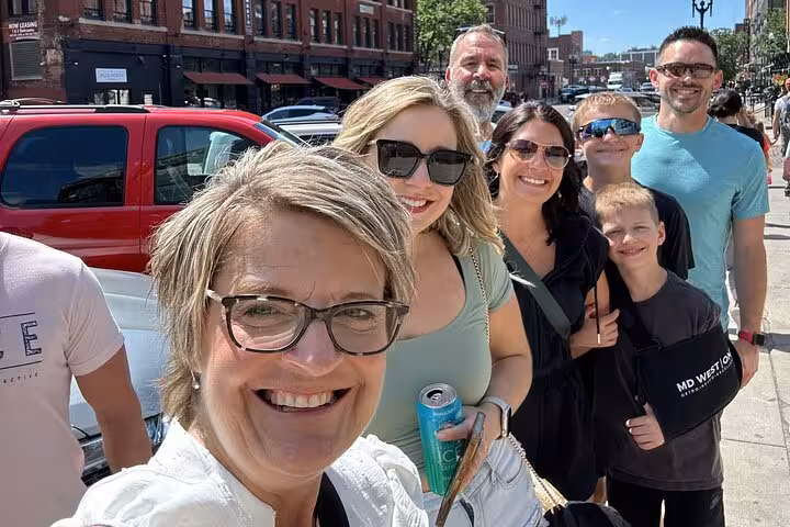 Excited family group selfie on sunny Omaha street enjoying the Wicked Glitch Oz themed interactive tour experience