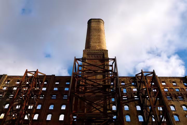 Abandoned industrial brick building with rusty steel scaffolding and chimney tower in Williamsburg Brooklyn