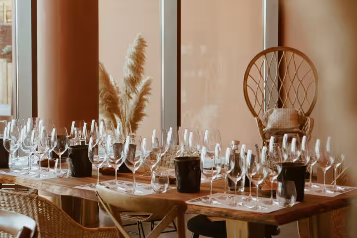 Elegant wine tasting setup with glasses and rustic decor in a sunlit room, perfect for a premium tasting event.