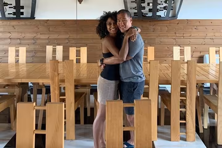 Cozy wine tasting room in Berat with a couple embracing amid elegant wooden decor.