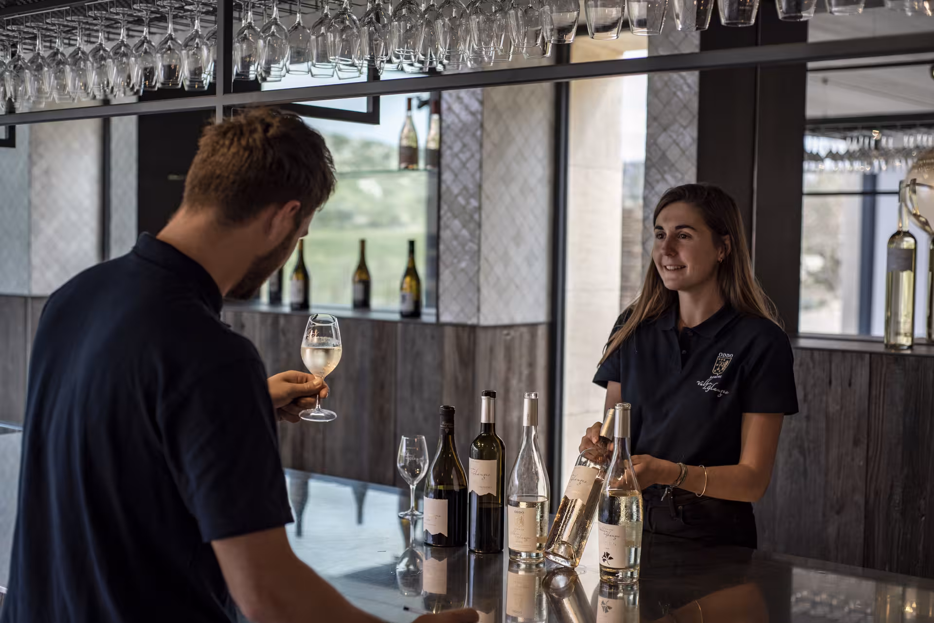 Dégustation de vins au Domaine du Vallon des Glauges, sommelier servant un verre au caveau de dégustation