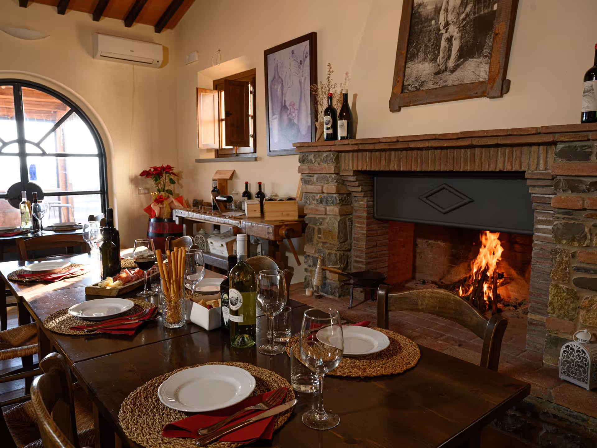 Cozy dining room with fireplace set for wine tasting and local food pairing near Livorno, Italy.
