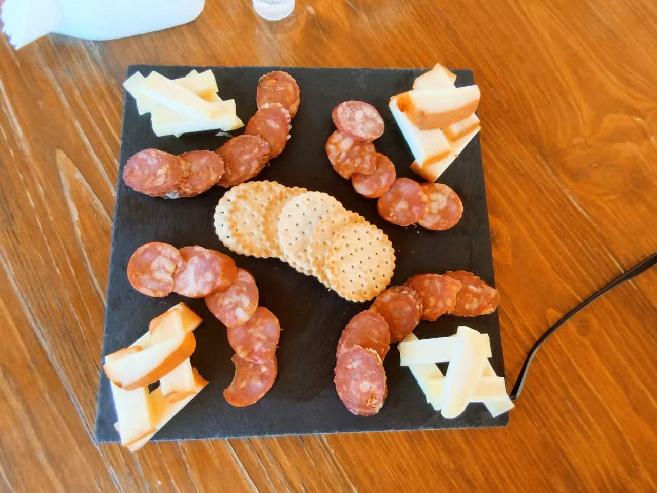 Gourmet platter with assorted cheeses, cured meats, and crackers for a wine tasting off-road adventure.