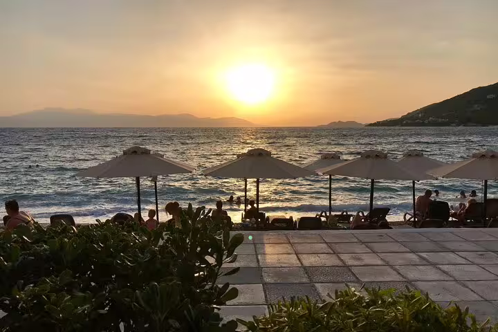 Sunset beach in Nafplio with umbrellas and sea views after wine tasting tour via Corinth Canal from Athens