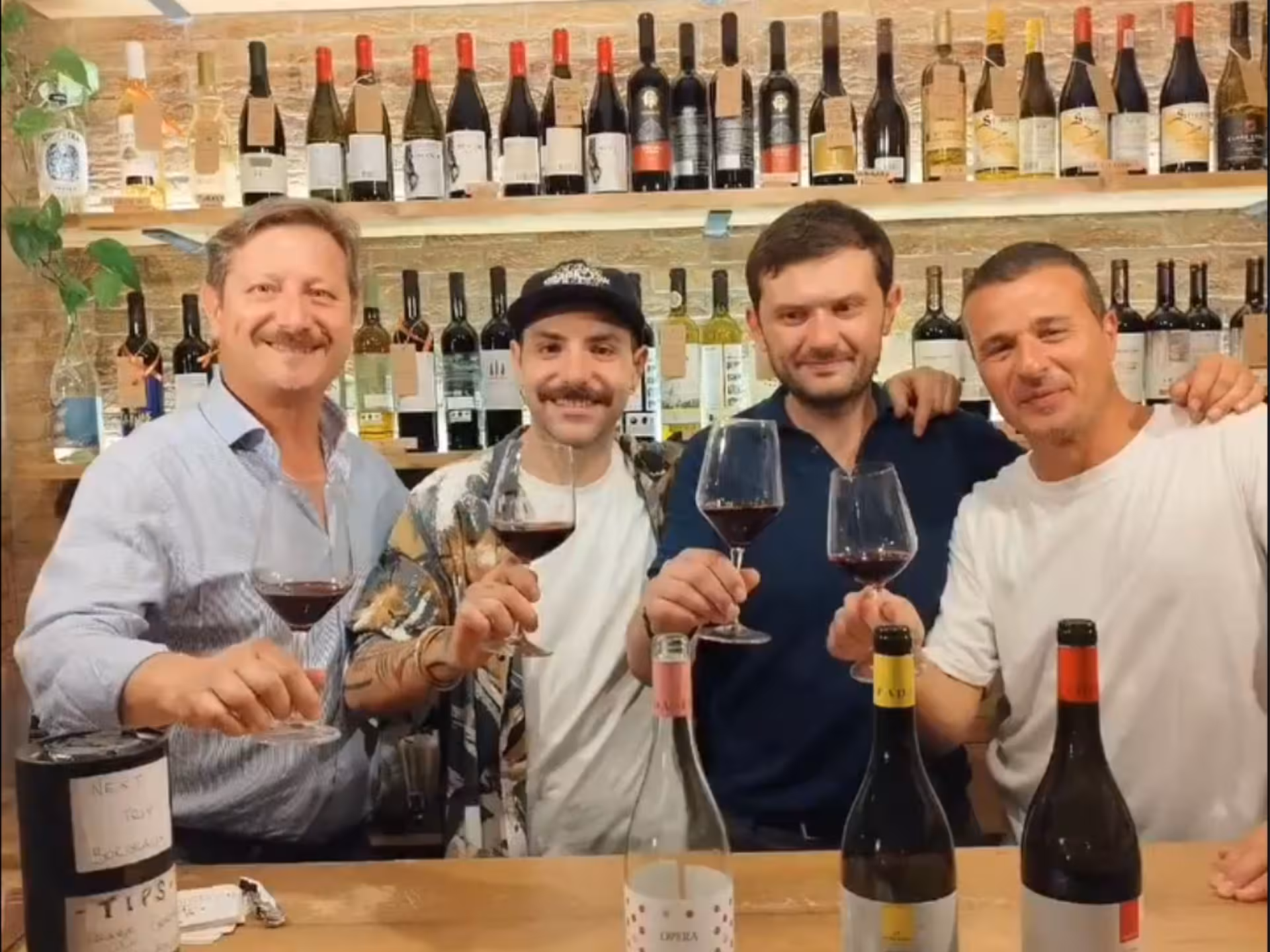Four friends raising glasses in a Naples wine bar, savoring wine tasting experience with authentic local pairings.
