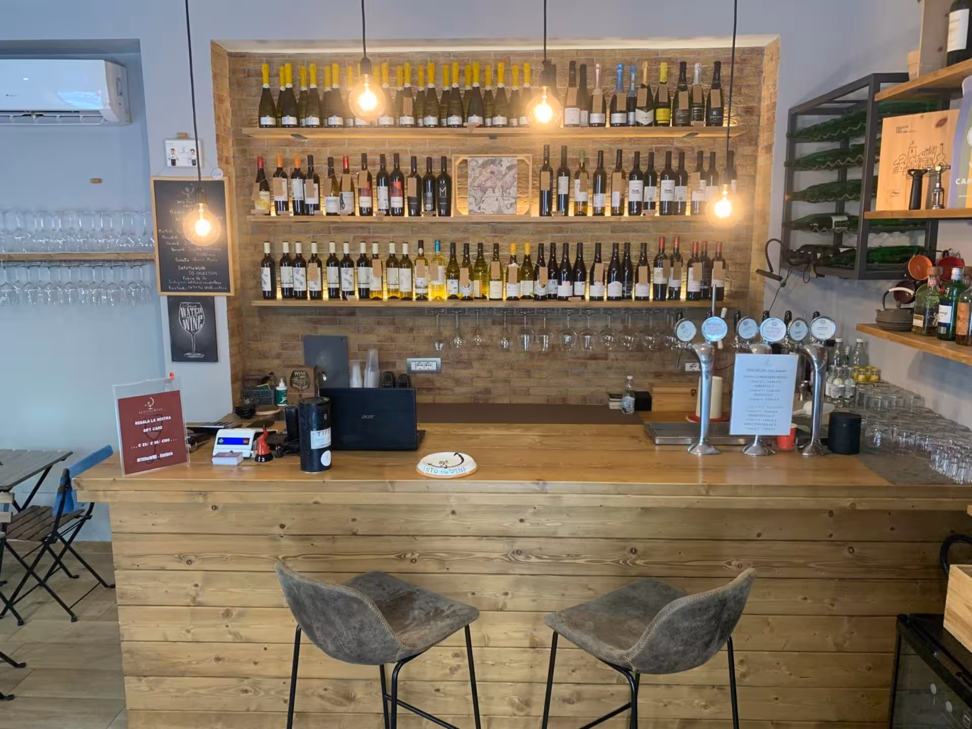 Charming wine bar interior in Naples with a rustic wooden counter, wine bottles, and inviting ambiance for tastings.