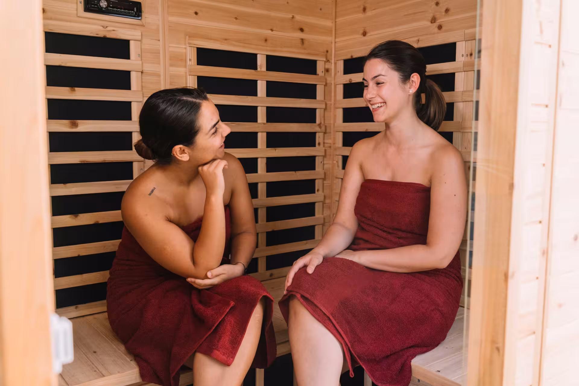 Two women in a sauna enjoy wine therapy during a Gallura winery tour in Olbia.
