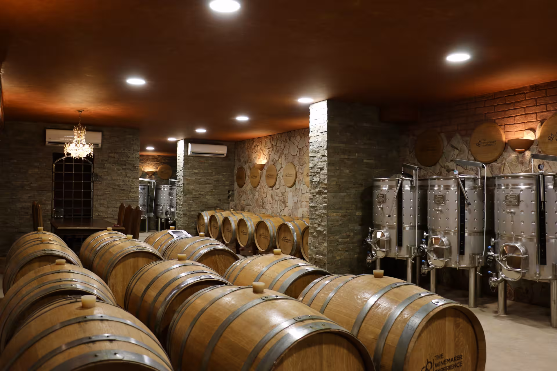 Rustic winery cellar with oak aging barrels and steel fermentation tanks for a bottle blending workshop