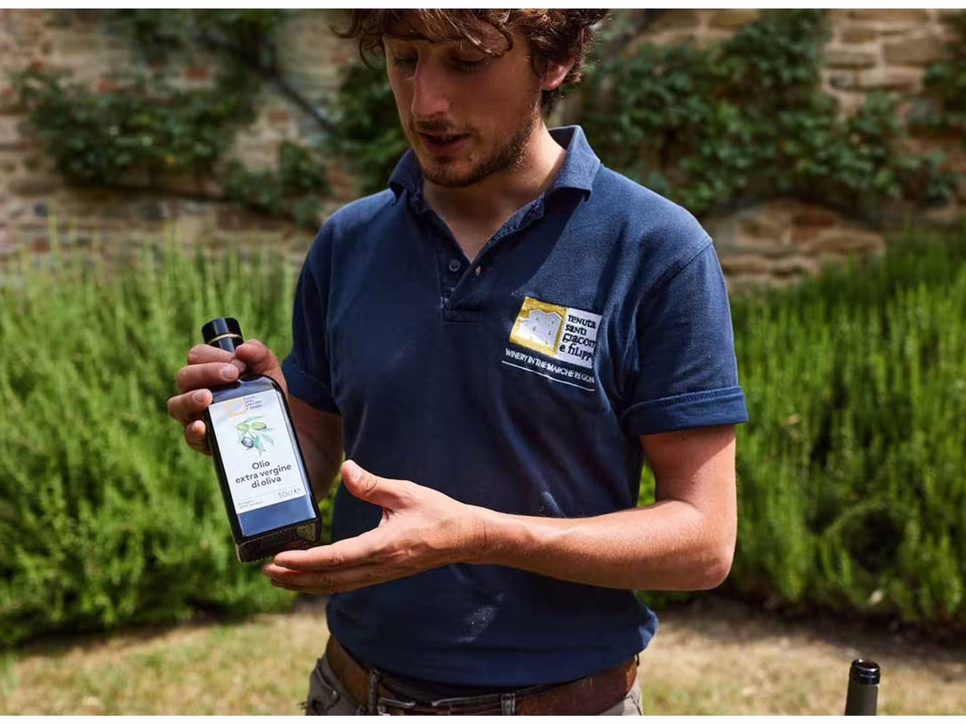 Winery host presenting local extra virgin olive oil during boutique winery tour and organic tastings near Urbino
