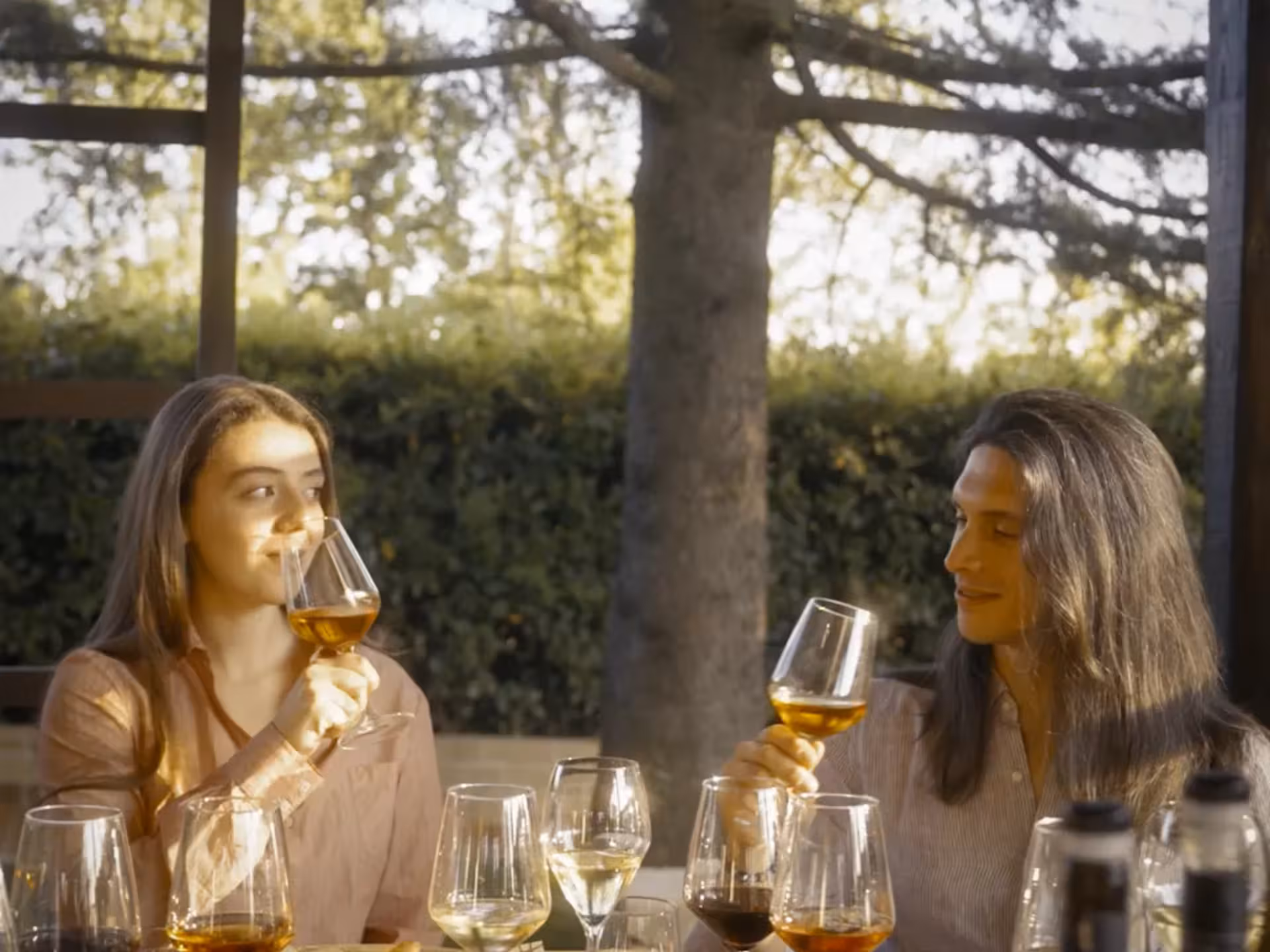 Two people enjoying a wine tasting experience in the scenic Rieti countryside, surrounded by lush greenery.