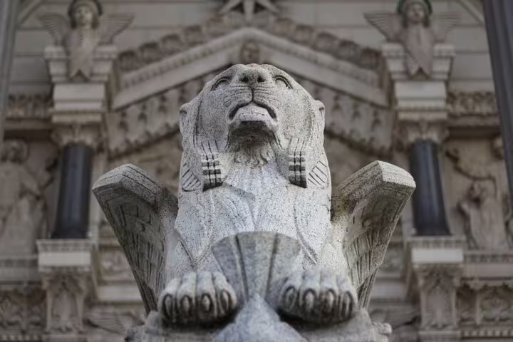 Stone winged lion sculpture at historic building facade in Lyon city center