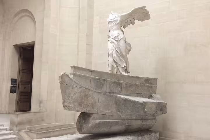 Winged Victory of Samothrace marble statue on ship prow pedestal at the Louvre Museum