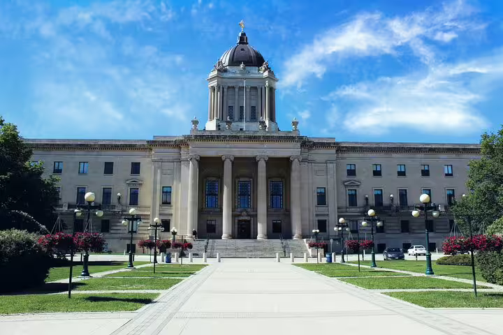 Manitoba Legislative Building with neoclassical columns, dome, and green lawns in Winnipeg