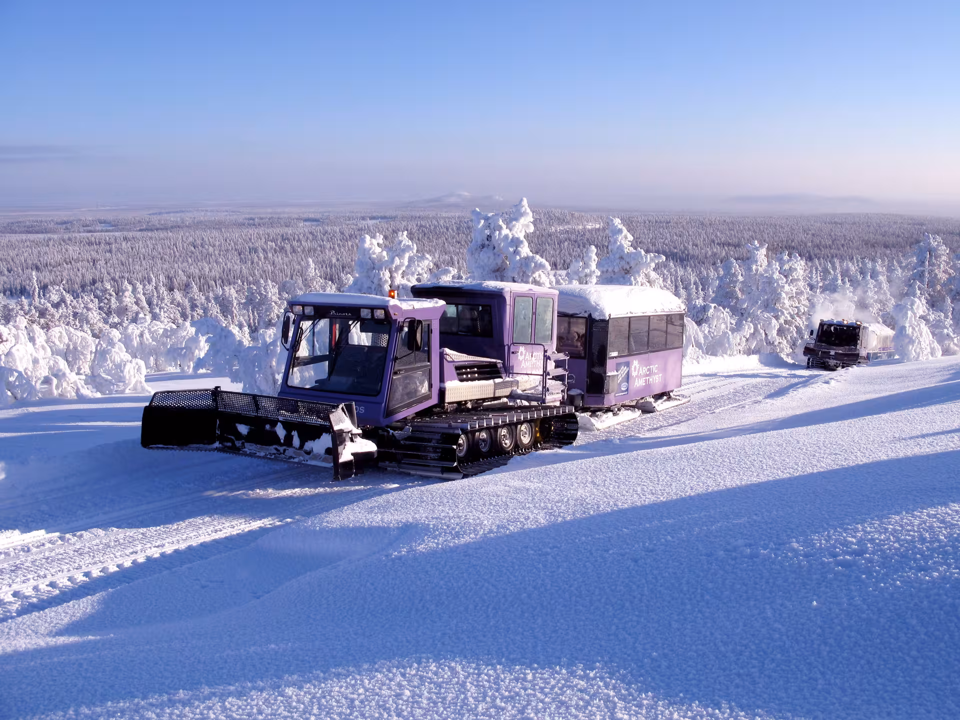 Purple snowcat vehicle on snowy Lapland terrain, ideal for a winter amethyst mine adventure experience.