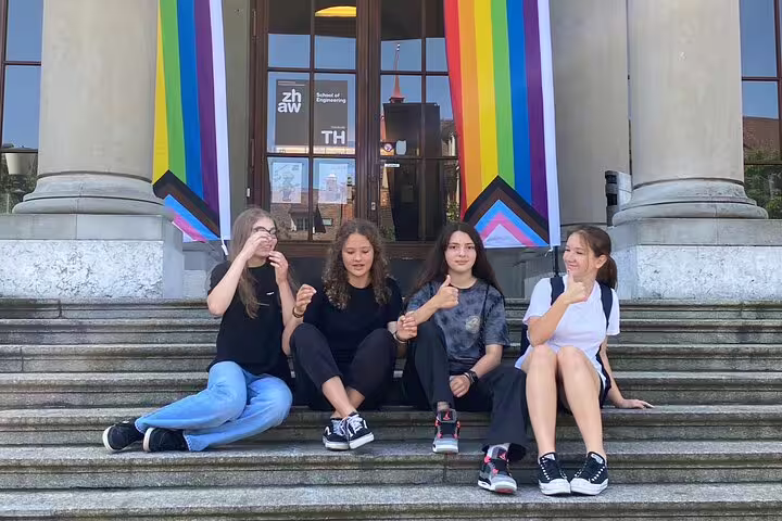 Teens relaxing on steps with rainbow flags in Winterthur on a self-guided scavenger hunt sightseeing tour