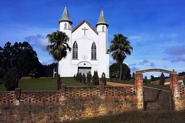 Discover historical German architecture at a charming church in Witmarsum Colony, Paraná, surrounded by lush greenery.