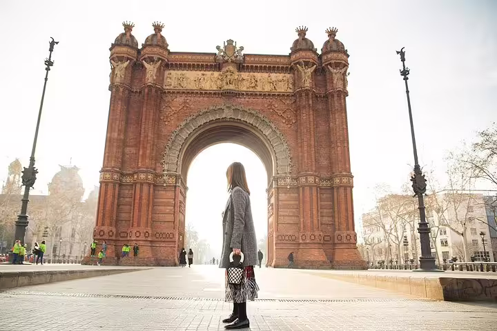Woman standing at Arc de Triomf Barcelona for Instagram Regular Tour, iconic landmark photo spot in golden light