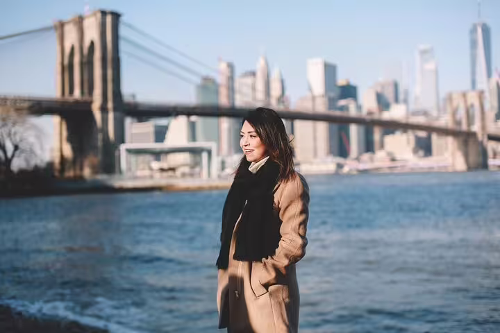 Woman posing by Brooklyn Bridge Park with Manhattan skyline, portrait stop on Brooklyn & DUMBO photo tour