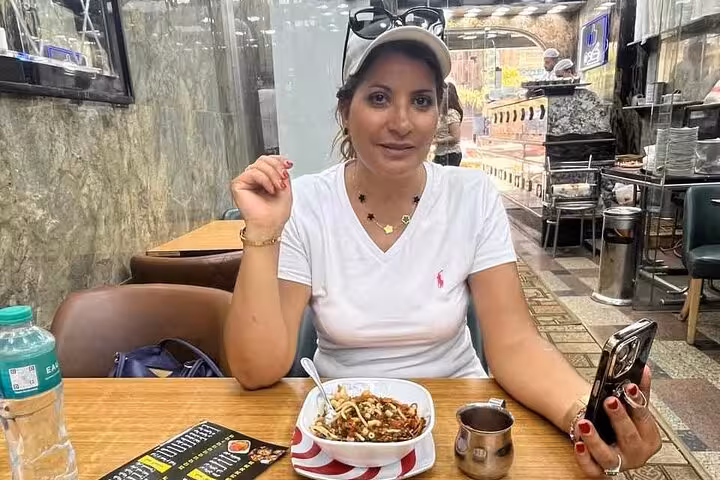 Woman enjoying koshari at a local Cairo eatery during a private food tour and funny walking experience