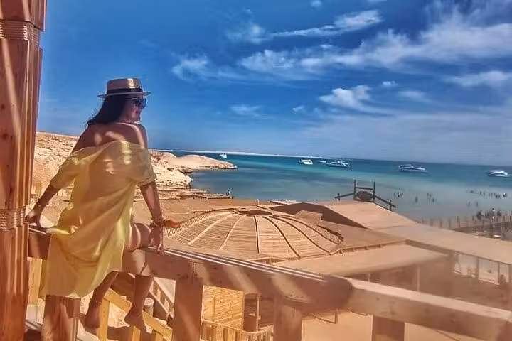 Woman overlooking Giftun Island beach from wooden deck, Hurghada sea trip with snorkeling, lunch and water sports