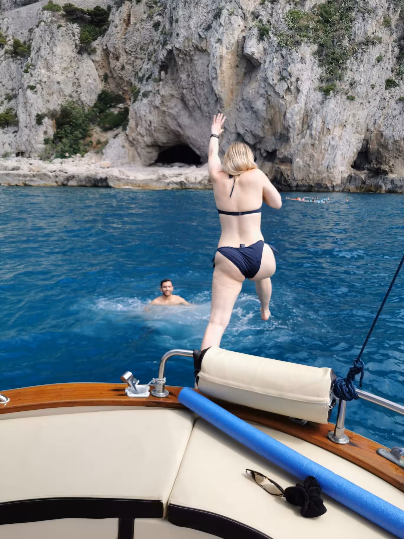 Woman jumping into the clear blue waters near Positano during a private boat tour from Sorrento.