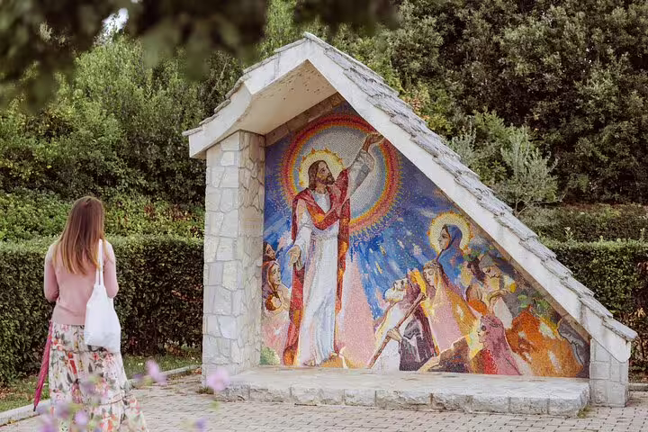 Woman viewing religious mosaic shrine in Medjugorje, Bosnia on a private pilgrimage tour day trip