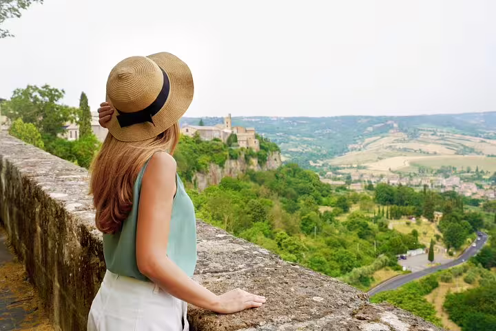Woman in a hat enjoying panoramic views of Orvieto's lush landscape during a private guided tour from Rome with lunch included.
