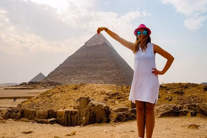 Woman posing with Pyramid of Giza on Cairo full-day customized adventure tour, private sightseeing and camel ride