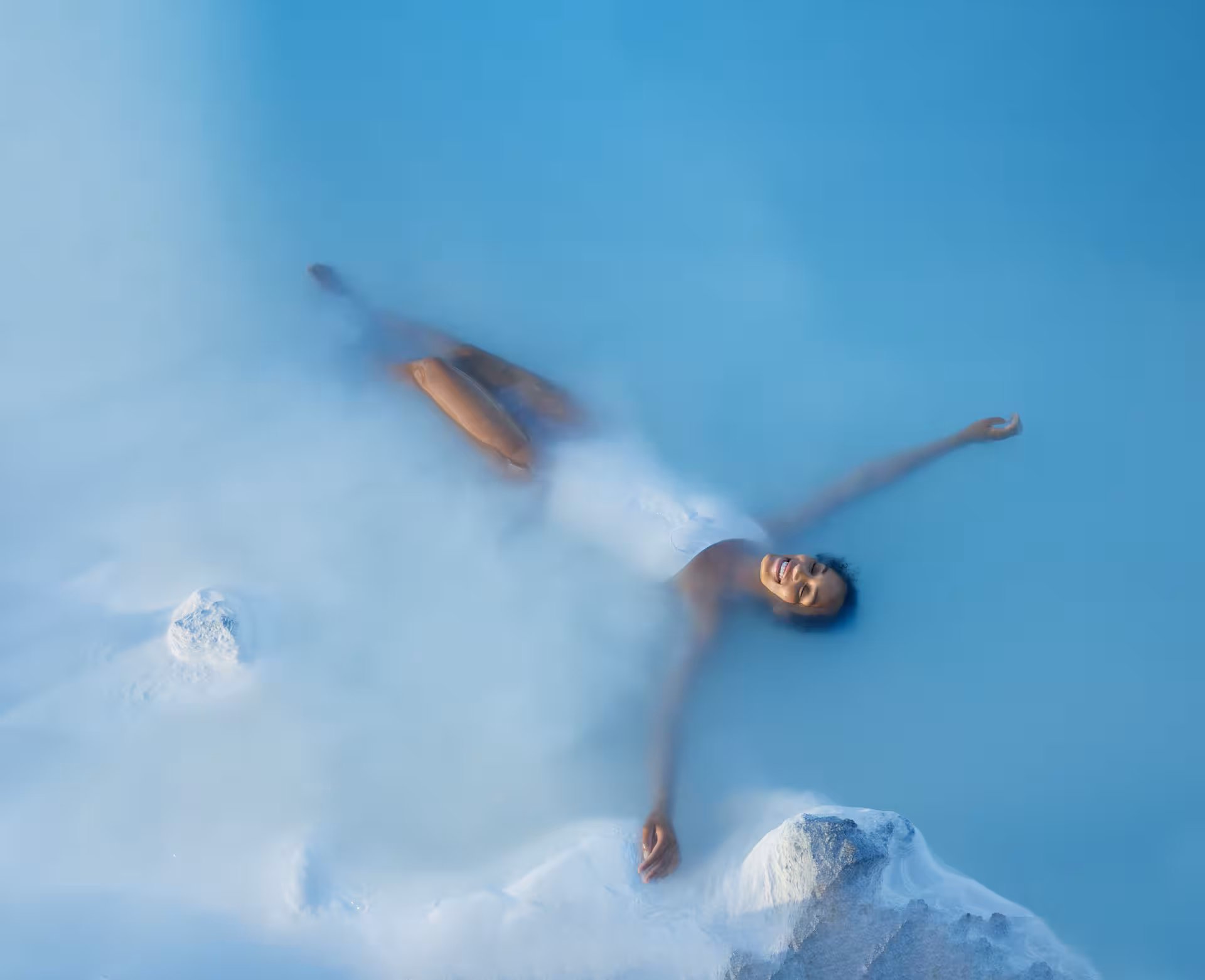 Woman relaxing and floating in the soothing waters of Iceland's famous Blue Lagoon during a 4-day stopover.
