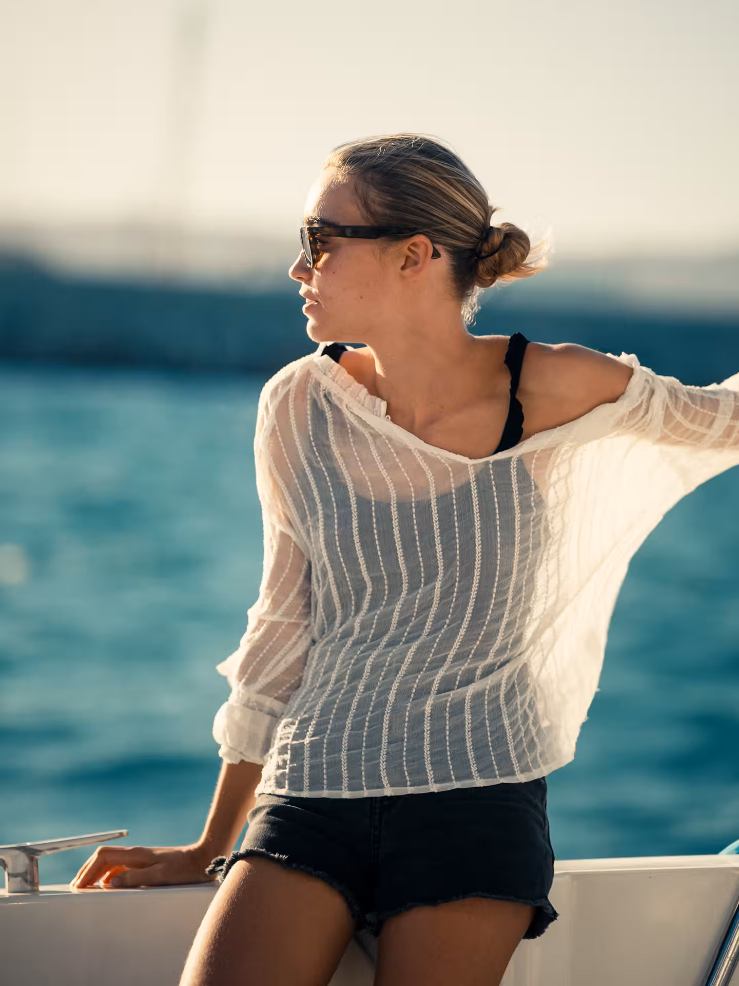 Woman relaxing on yacht at golden hour with sea backdrop, Wellness & Sea Breeze coastal cruise vibe
