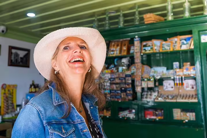 Smiling woman in a hat explores a charming souvenir shop on the Óbidos, Nazaré, Alcobaça, Batalha, Fatima tour from Vicentine Coast.