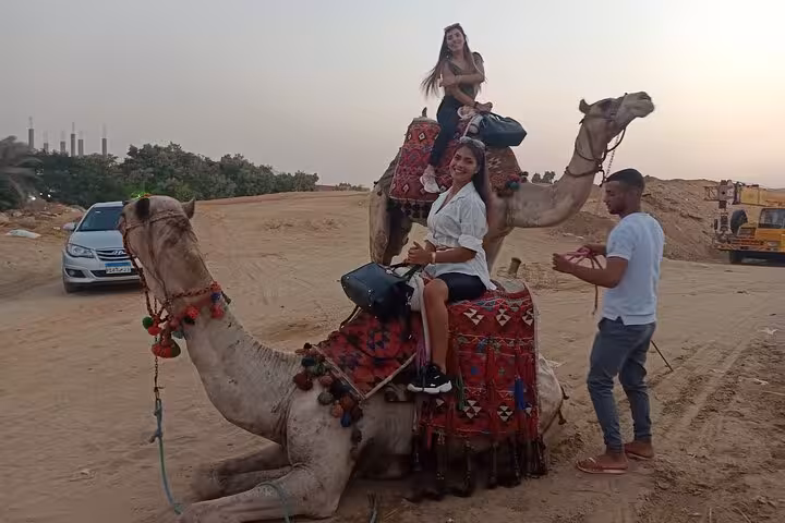 Women riding decorated camels in Giza desert, private pyramids and Sphinx tour with camel ride experience