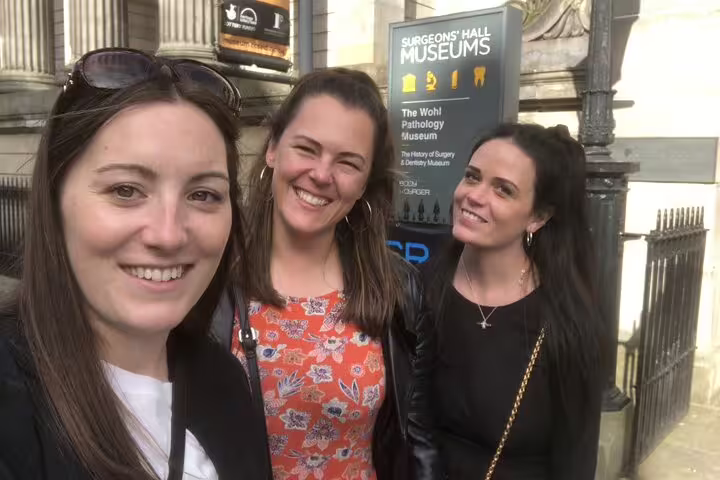 Three smiling women taking a selfie outside Surgeons' Hall Museums in Edinburgh