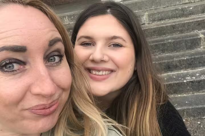 Two smiling women taking a selfie outdoors near stone steps in Letchworth Garden City