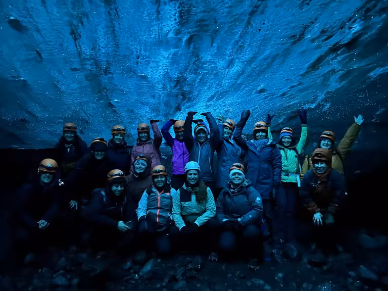 Group of women celebrating inside an ice cave during a women-only Viking winter adventure tour.