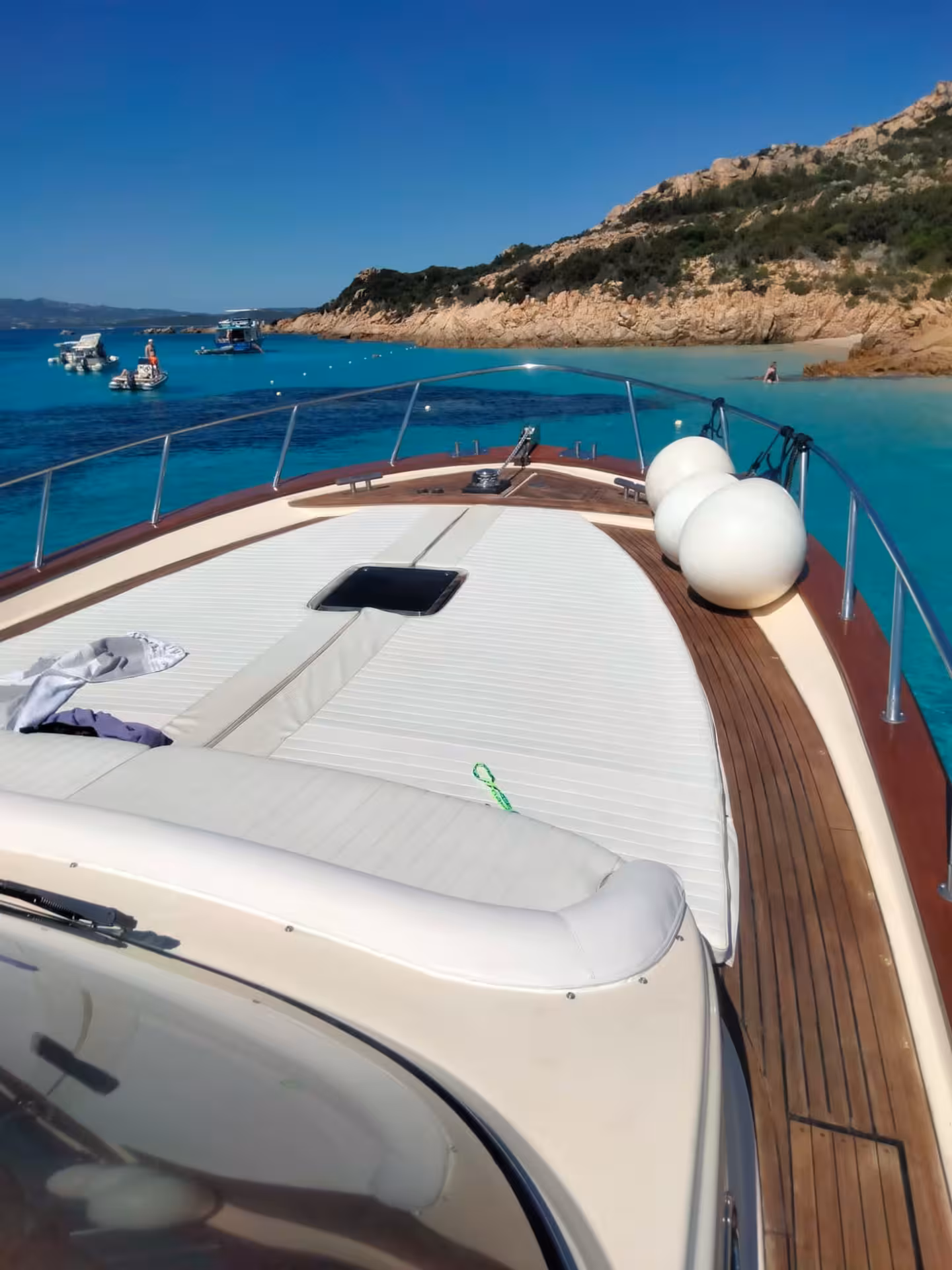 Luxurious wooden boat anchored in azure waters near the pristine beaches of La Maddalena, Corsica.