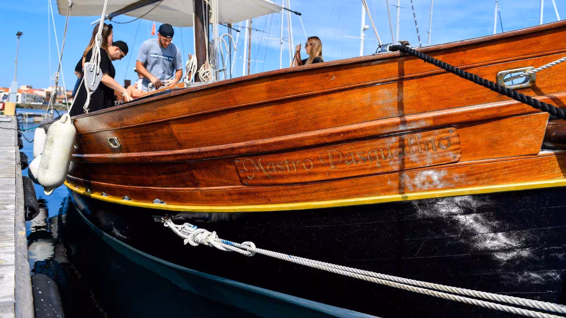 Close-up of a wooden sailboat at the dock, preparing for the Stintino to Asinara sailing adventure.