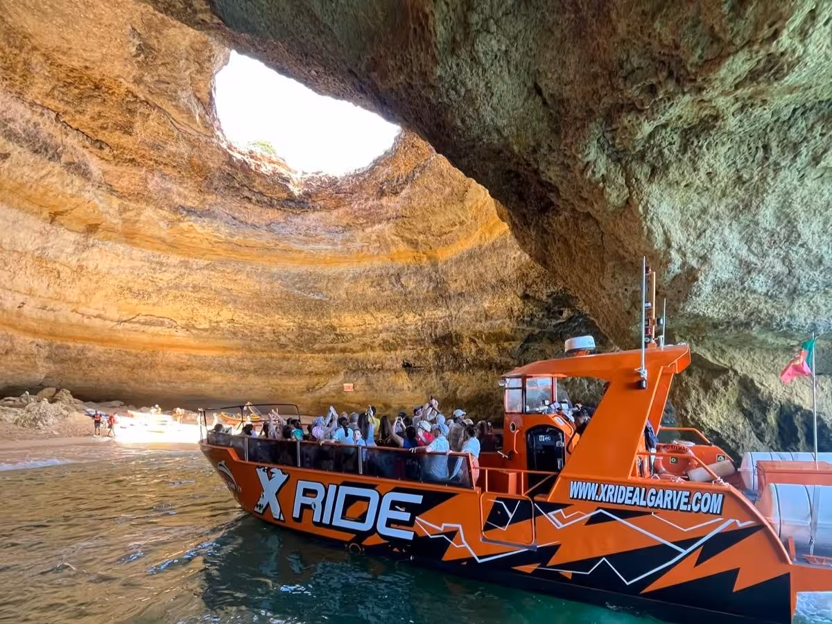 X Ride Algarve boat entering the famous Benagil cave with visitors on a guided Algarve coastline and dolphin tour
