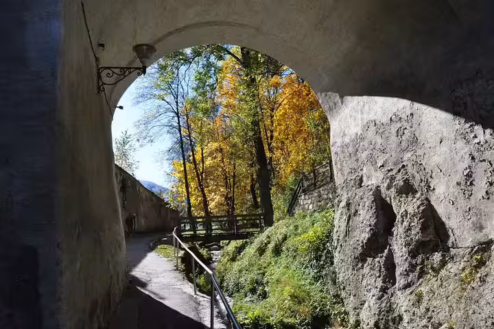 Stone arch tunnel framing autumn trees in Brasov Old Town walking tour