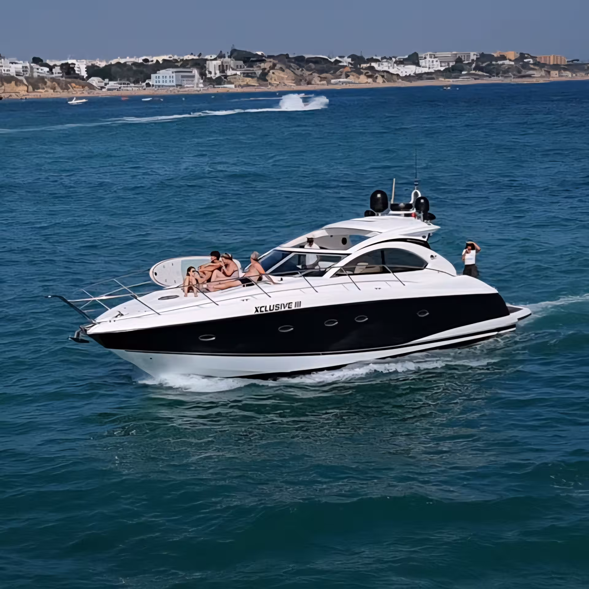 Group sunbathing on XCLUSIVE III Private Luxury Yacht as it glides along Algarve coast on a premium private boat tour