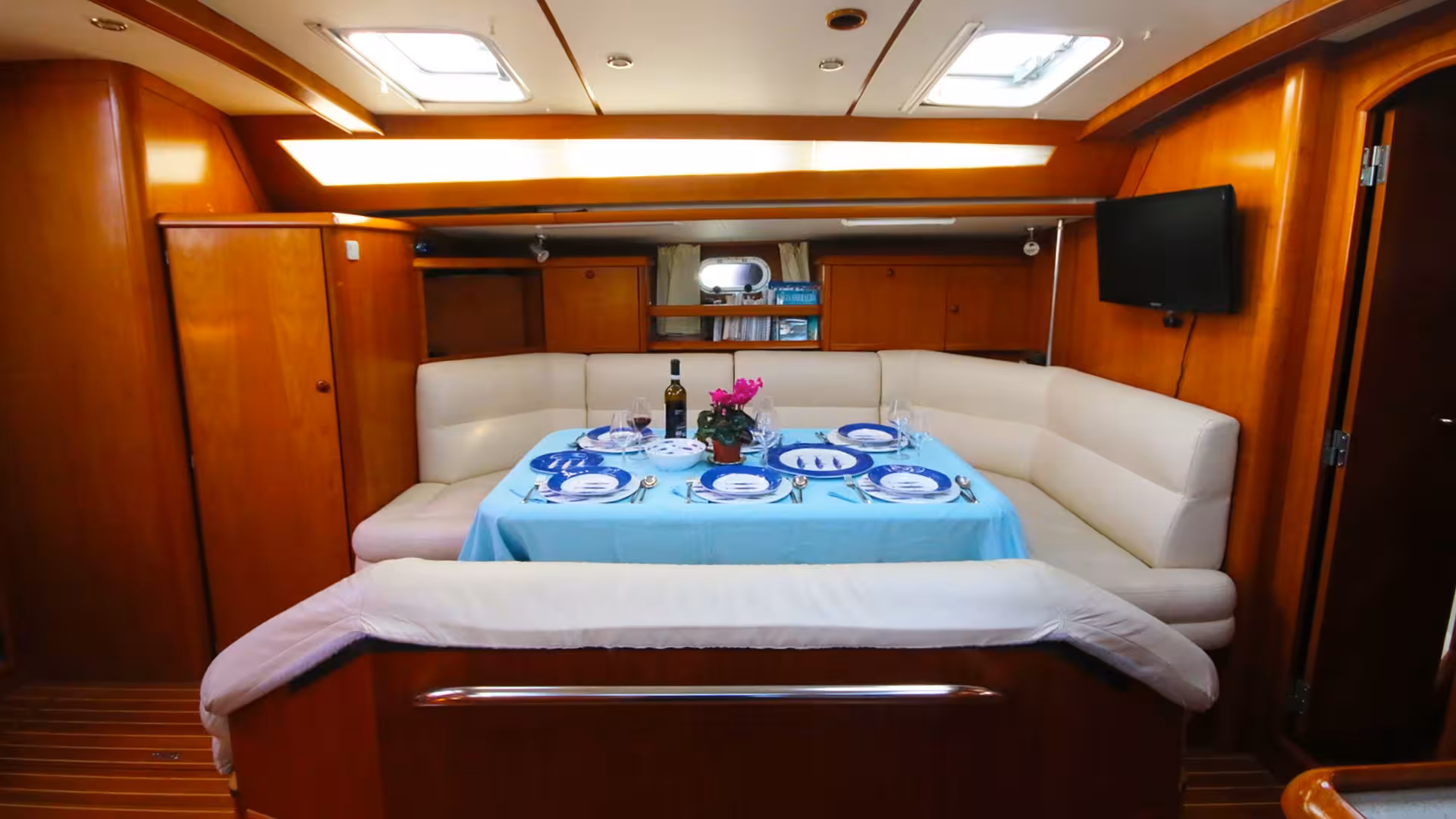 Elegant yacht interior dining area set for a meal, offering comfort during Gulf of Orosei sailing trips from Arbatax.