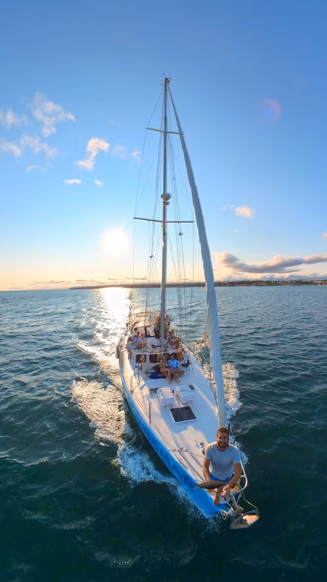 Yacht FINISMAR sailing with happy passengers enjoying a private 2-hour tour under a breathtaking sunset sky.