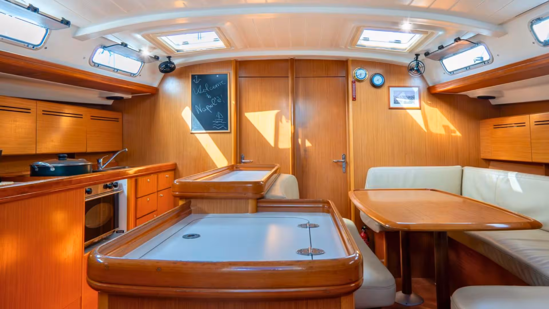 Cozy yacht interior with wooden furnishings on a sailing trip to La Maddalena Archipelago from Santa Teresa di Gallura.