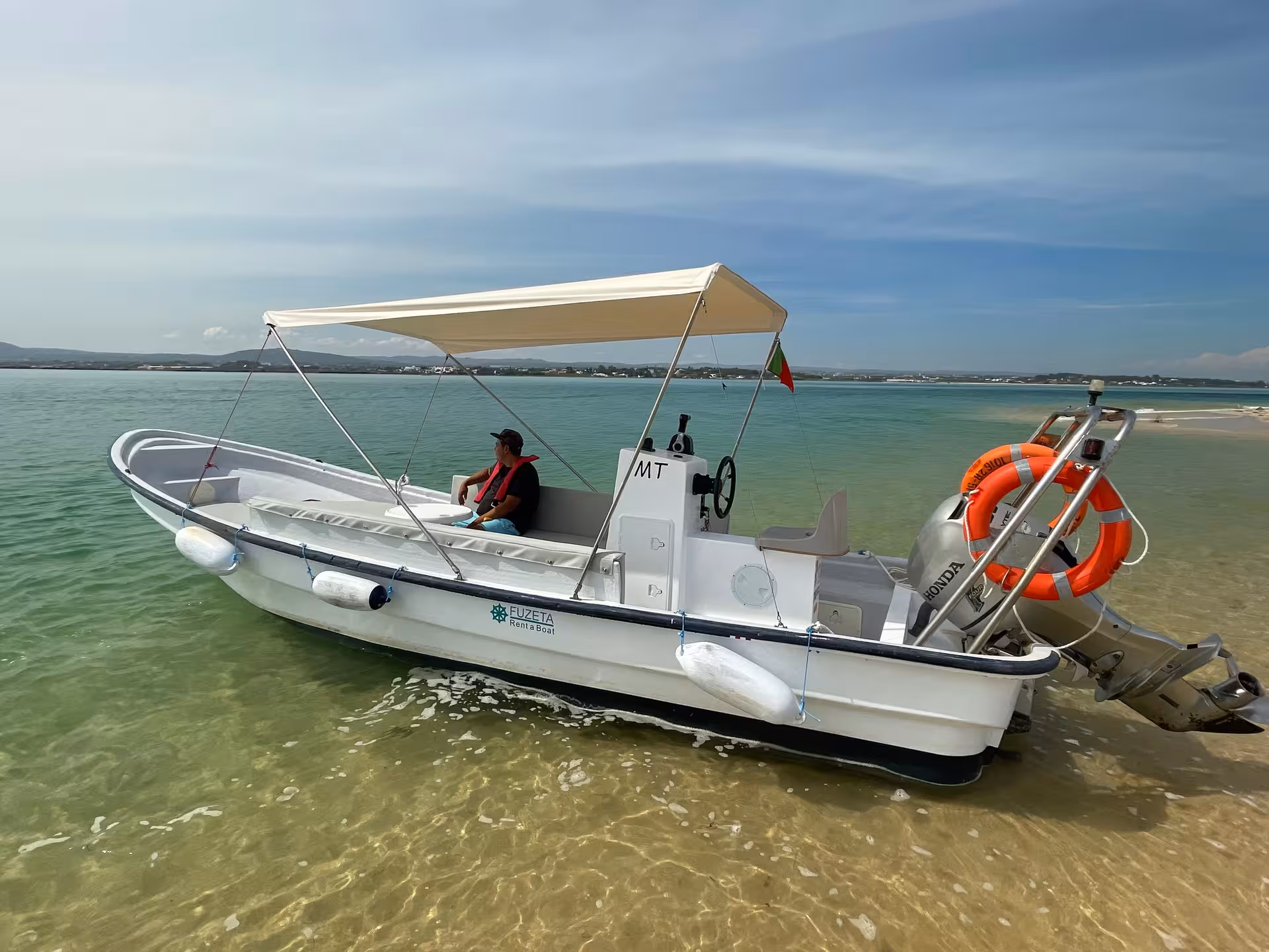 Yamaha speed boat rental anchored in shallow clear water with sun canopy, great Algarve lagoon day cruise